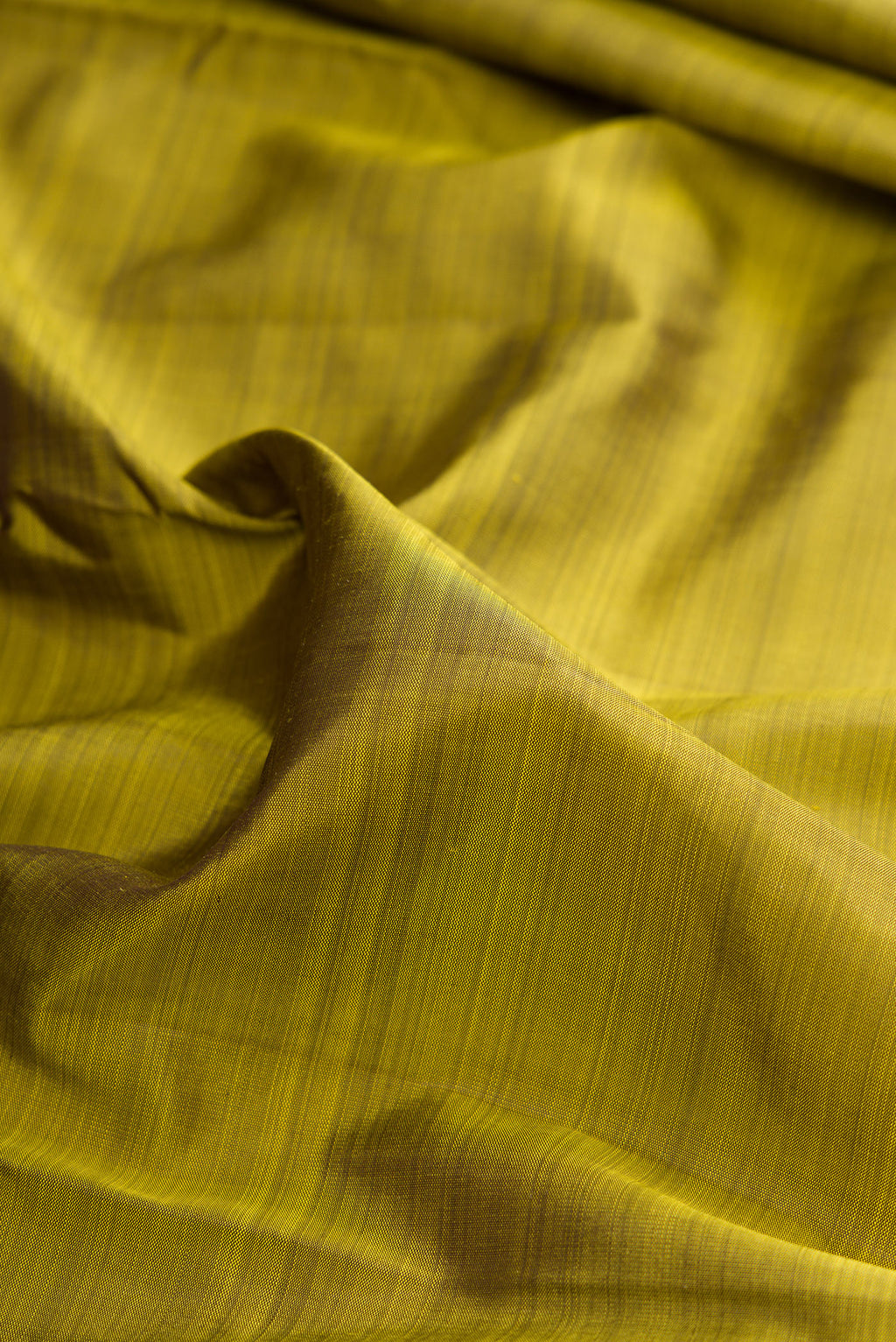 Close up of Pure Silk Mehandi Green Dual Tone Kanjivaram Saree with Plain Body and Temple Border.  displaying folds