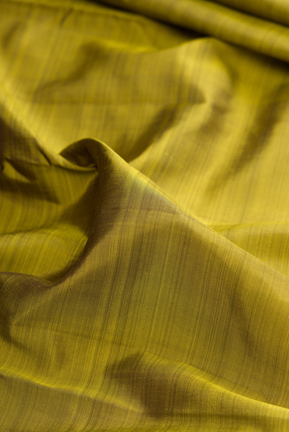Close up of Pure Silk Mehandi Green Dual Tone Kanjivaram Saree with Plain Body and Temple Border.  displaying folds