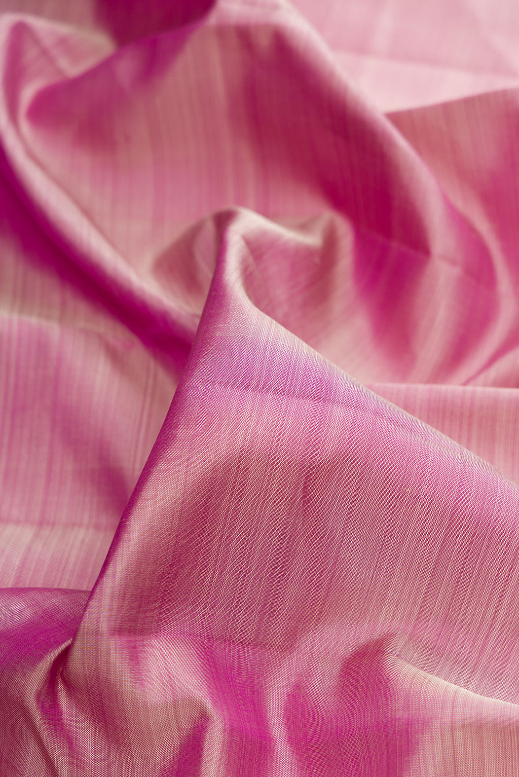 Close up of Pure Silk Pink Dual Tone Kanjivaram Saree with Plain Body and Rising Temple Border.  displaying folds