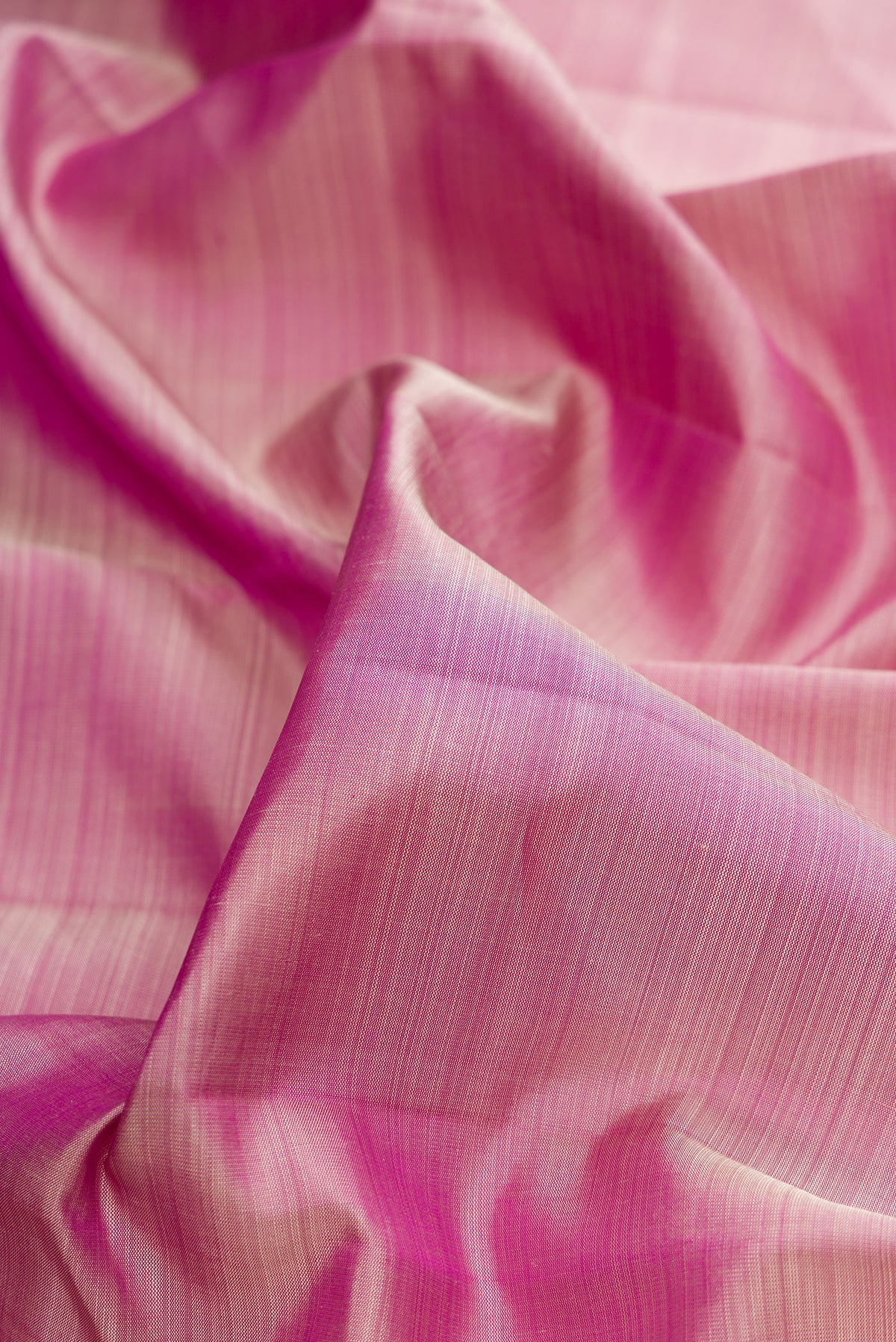 Close up of Pure Silk Pink Dual Tone Kanjivaram Saree with Plain Body and Rising Temple Border.  displaying folds