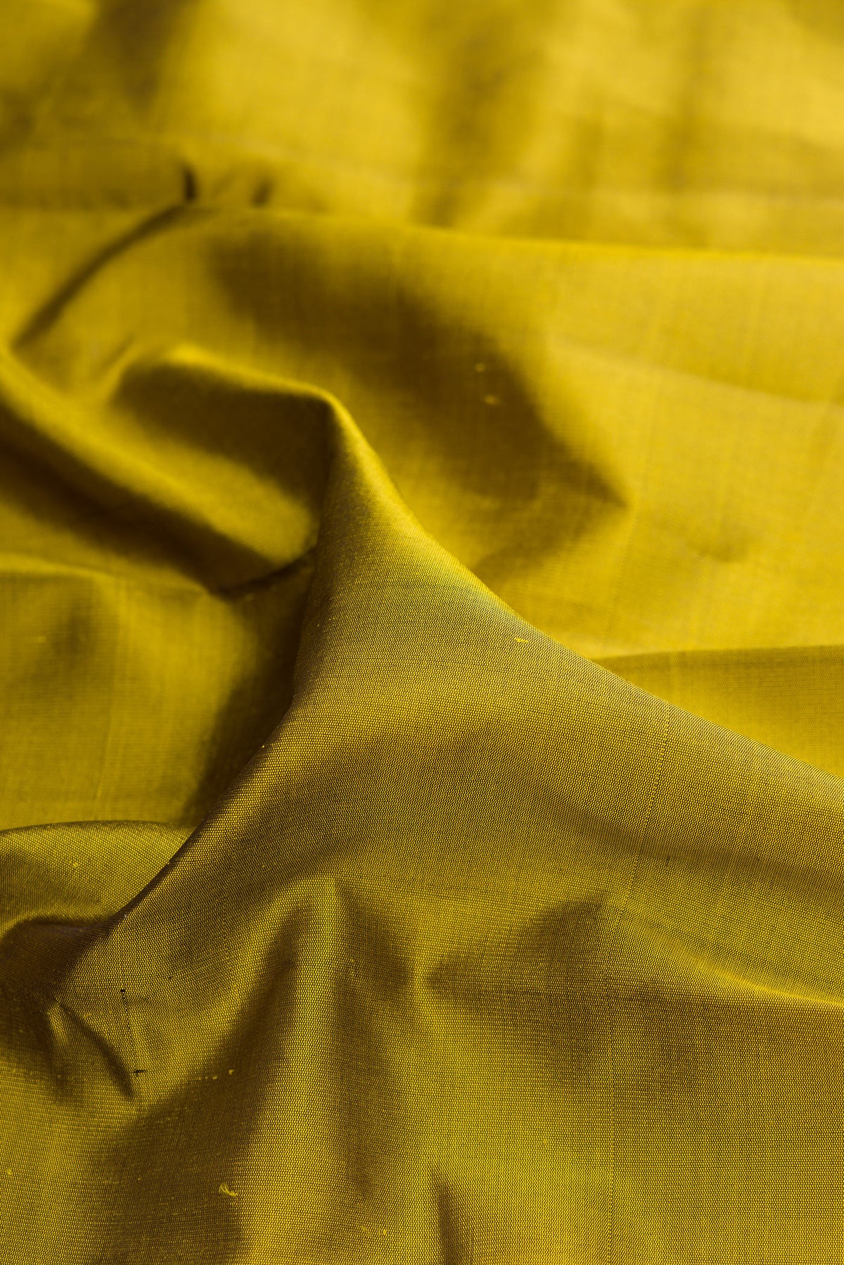 Close up of Pure Silk Mehandi Green Dual Tone Kanjivaram Saree with Plain Body and Temple Border.  displaying folds