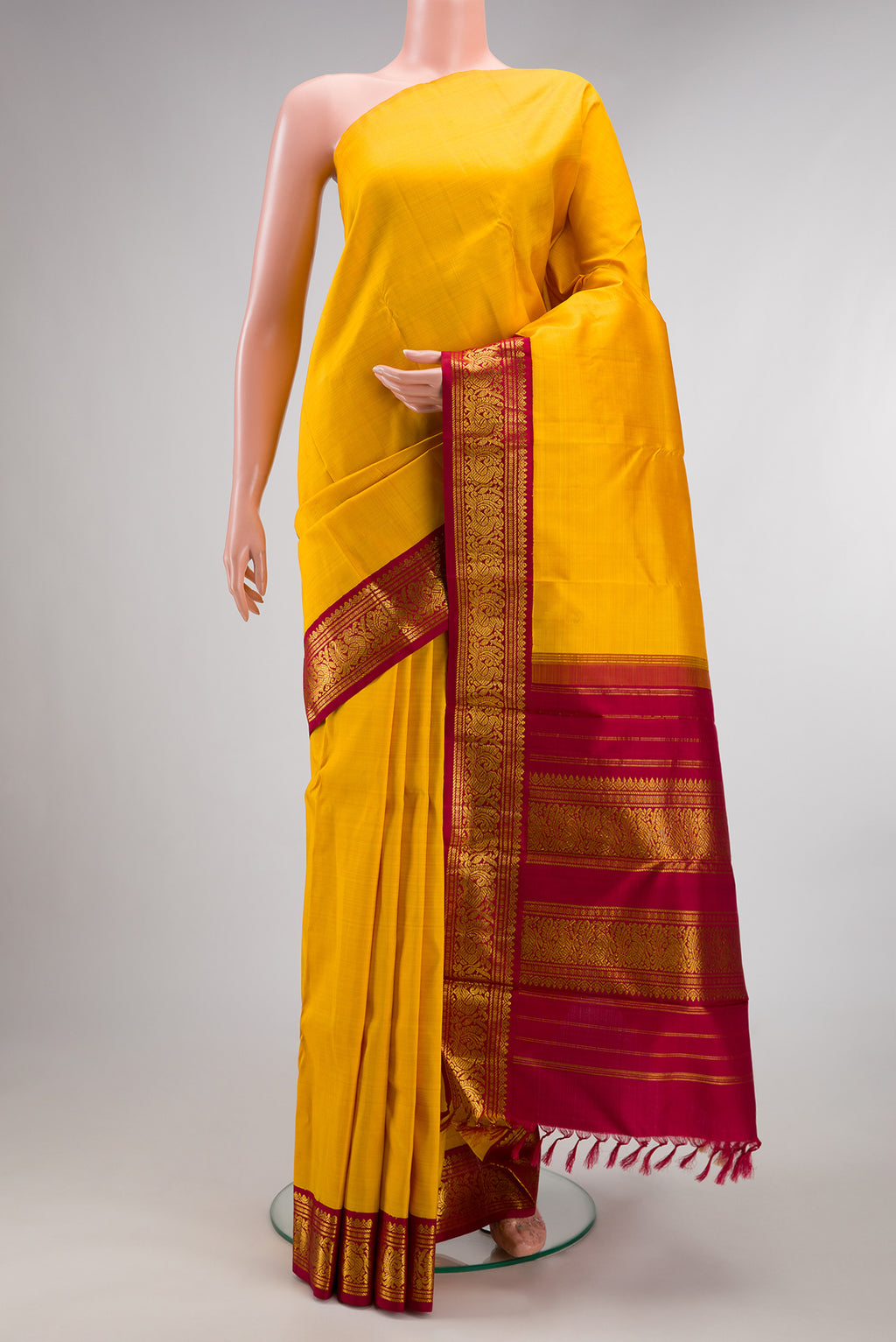 Pure Silk Pure Zari Yellow Dual Tone Kanjivaram Saree with Plain Body and One Side Border.  displayed on a mannequin