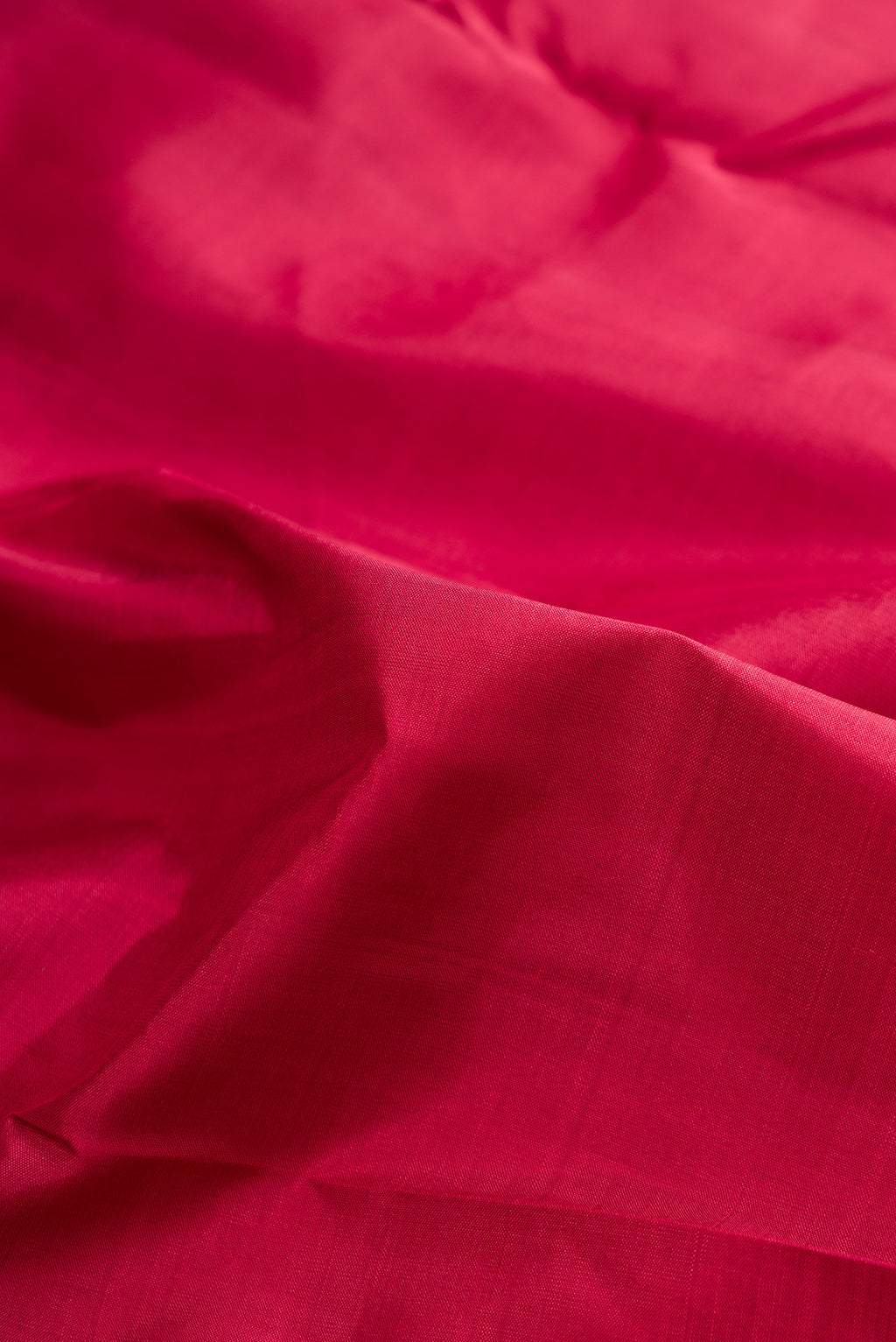 Close up of Pure Silk Pure Zari Deep Red Kanjivaram Saree with Plain Body and One Side Border.  displaying folds