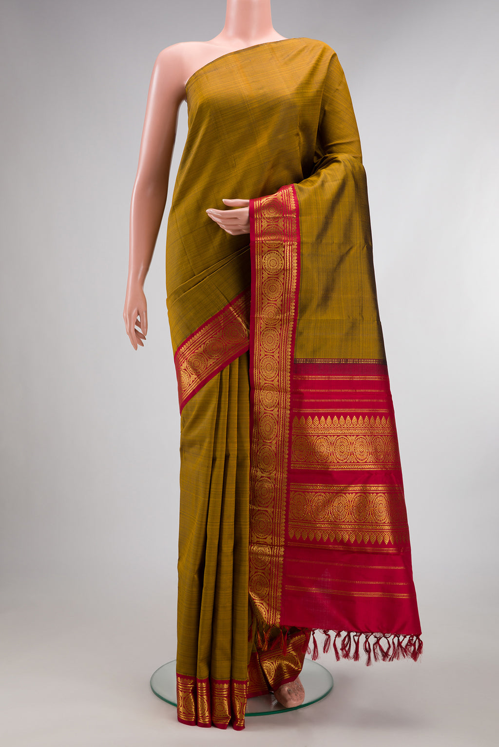Pure Silk Pure Zari Mehandi Green Dual Tone Kanjivaram Saree with Plain Body and One Side Border.  displayed on a mannequin