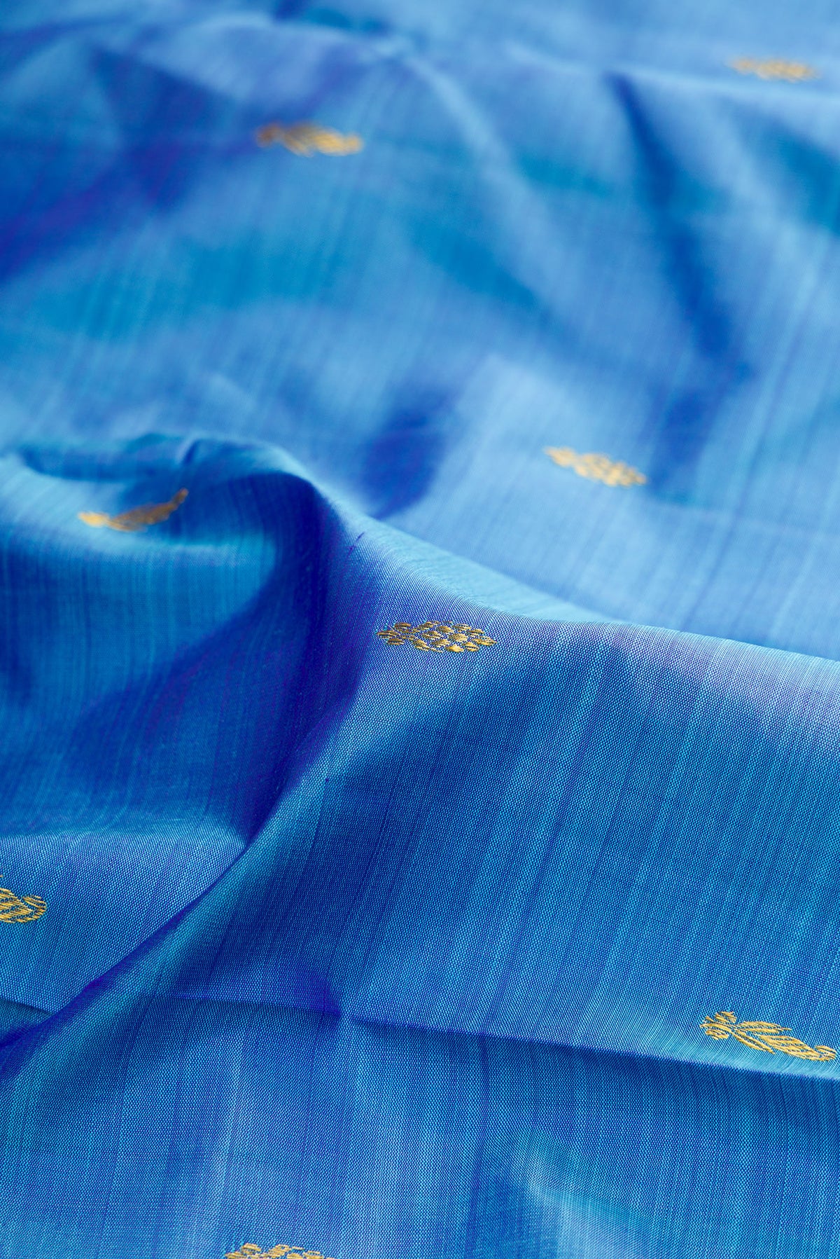 Close up of Pure Silk Pure Zari Sky Blue Kanjivaram Saree with Zari Butta on the body and One Side Border.  displaying folds