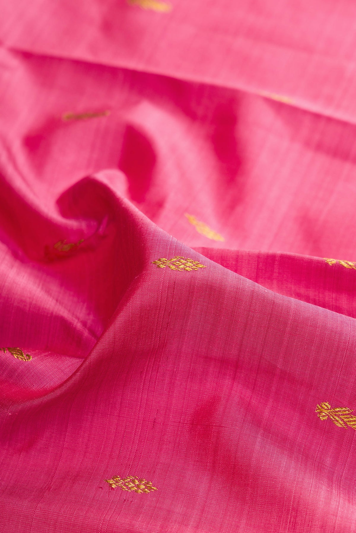 Close up of Pure Silk Pure Zari Pink Kanjivaram Saree with Zari Butta on the body and One Side Border.  displaying folds