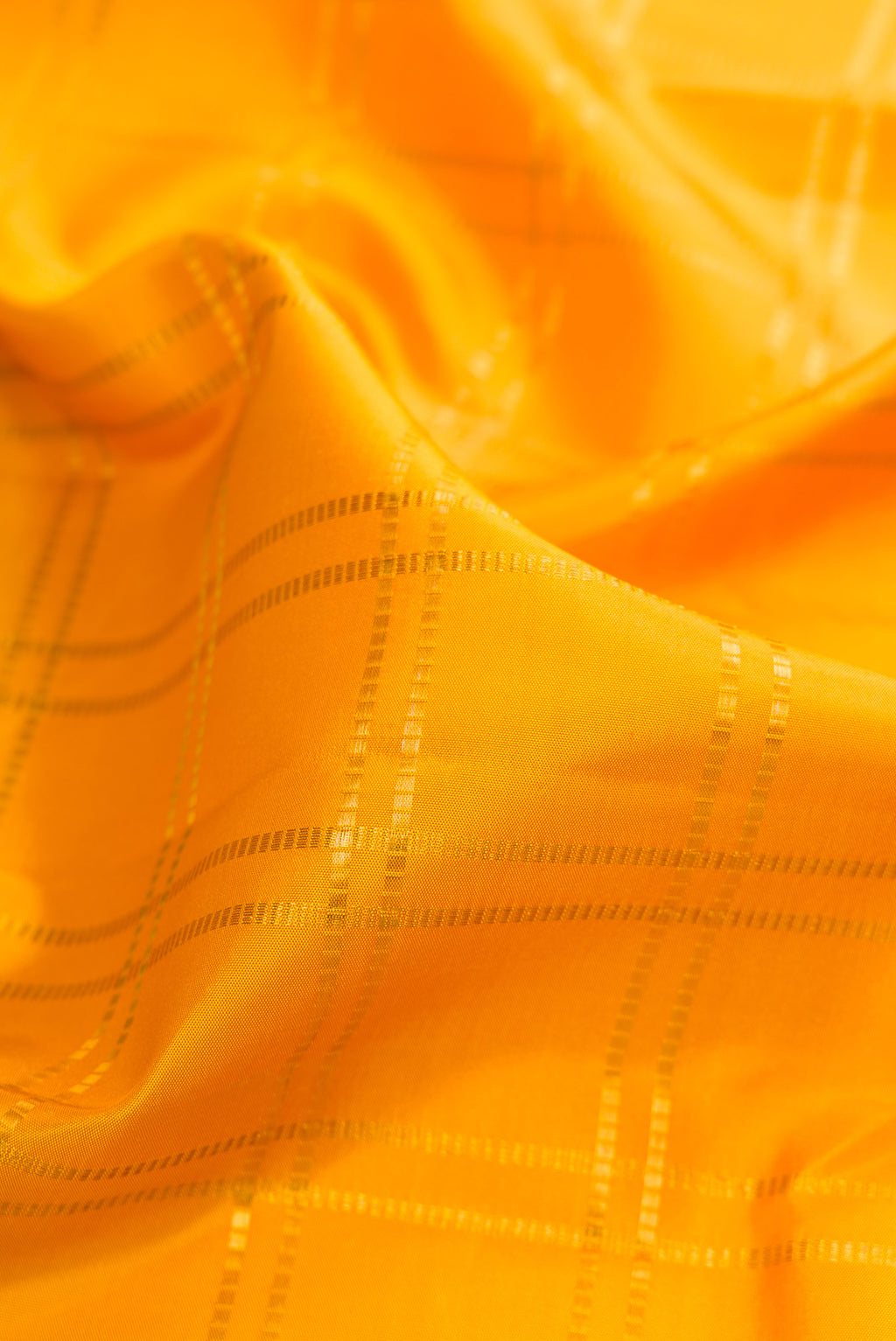 Close up of Pure Silk Yellow Kanjivaram Saree with Checked design on the body and Zari Border.  displaying folds
