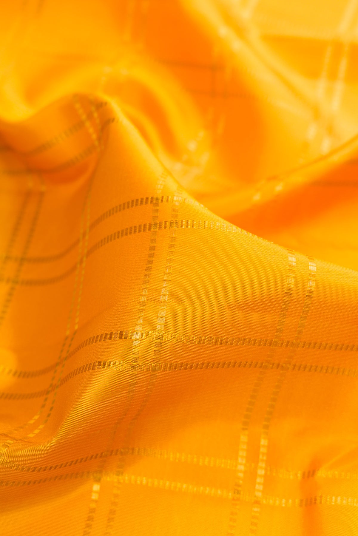 Close up of Pure Silk Yellow Kanjivaram Saree with Checked design on the body and Zari Border.  displaying folds
