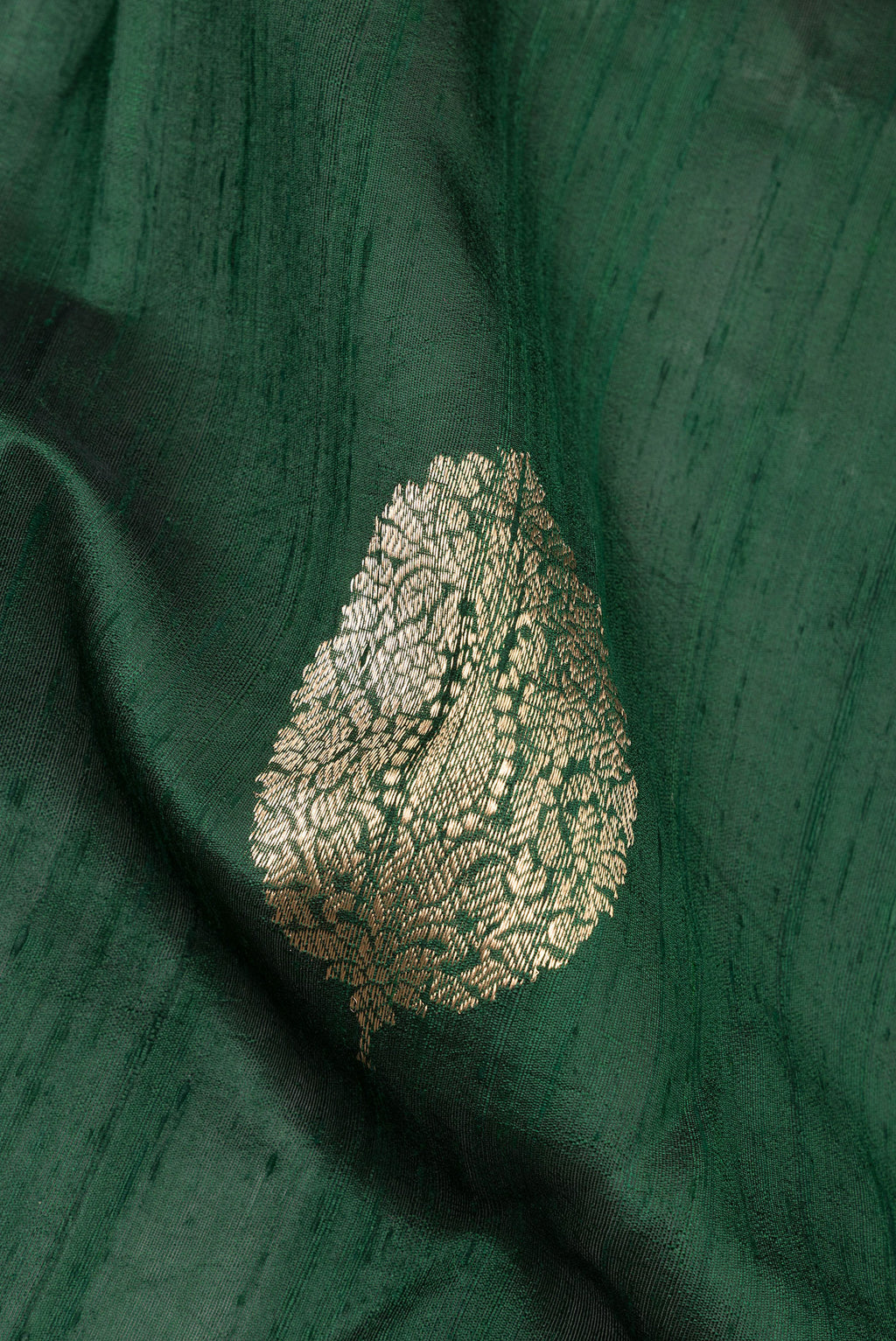 Close up of Pure Silk Bottle Green Banarasi Tussar Saree with Zari Butta on the body and Without Border.  displaying folds