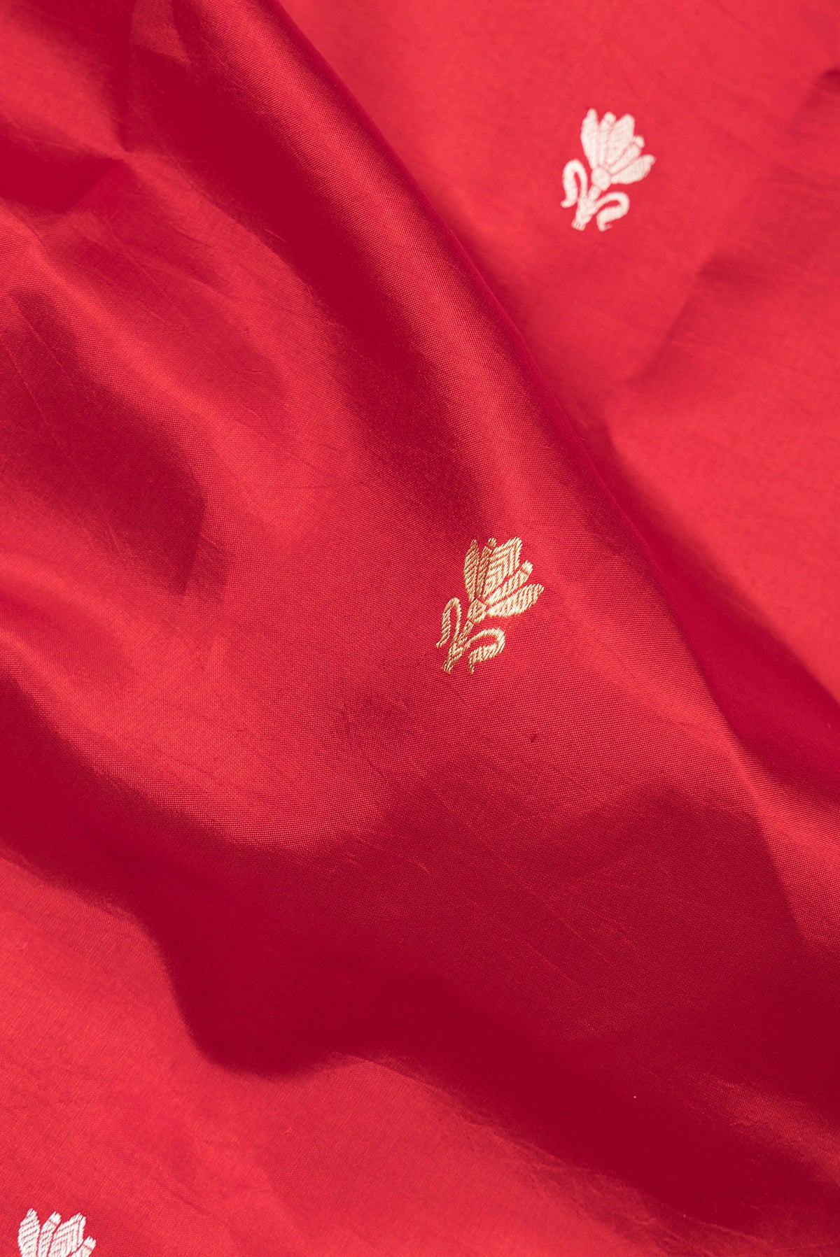 Close up of Pure Silk Red Banarasi Katan Saree with Zari Butta on the body and Fancy Border.  displaying folds