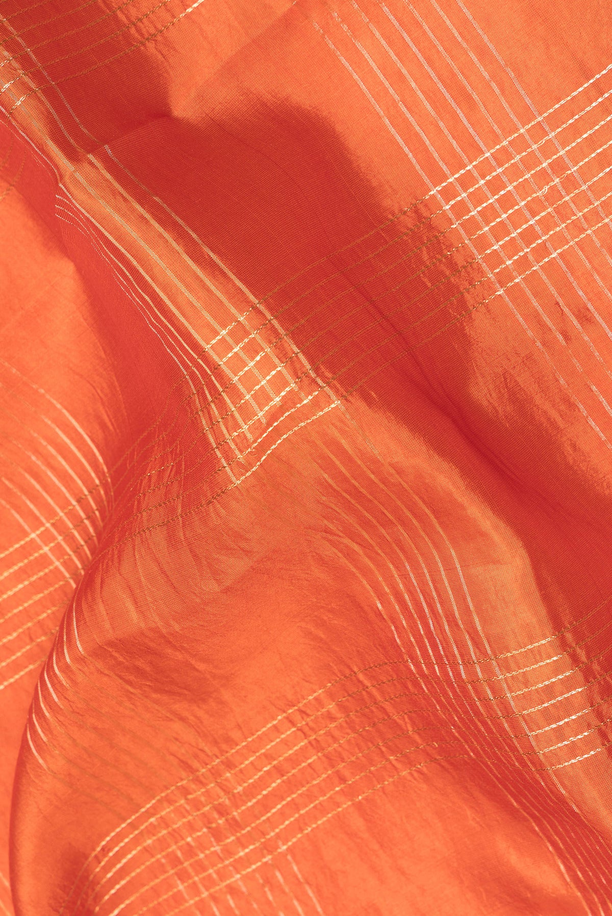 Close up of Orange Tussar Saree with Checked design on the body and Fancy Border.  displaying folds