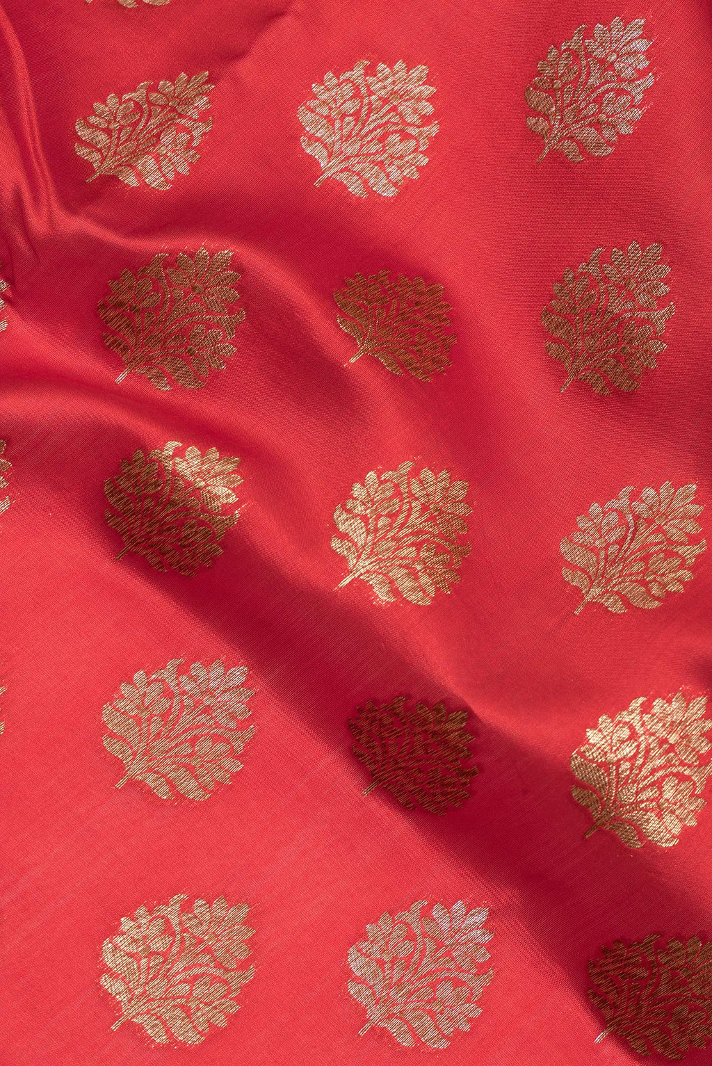 Close up of Red Raw Saree with Zari Butta on the body and Zari Border.  displaying folds