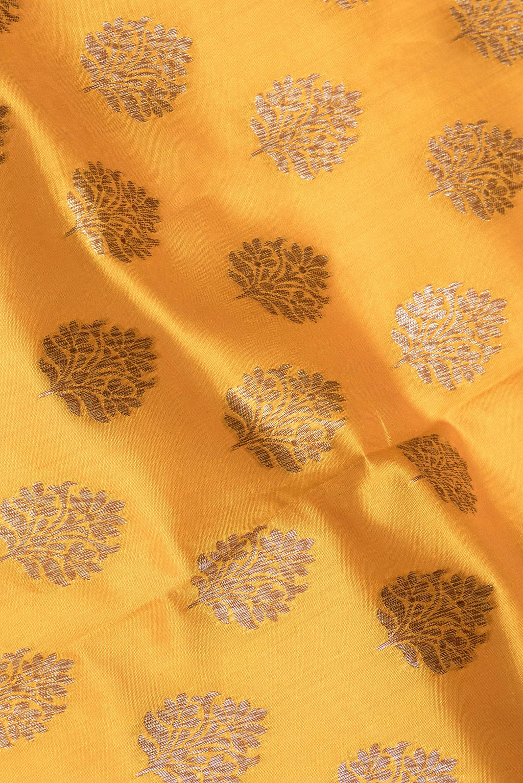 Close up of Mustard Raw Saree with Zari Butta on the body and Zari Border.  displaying folds