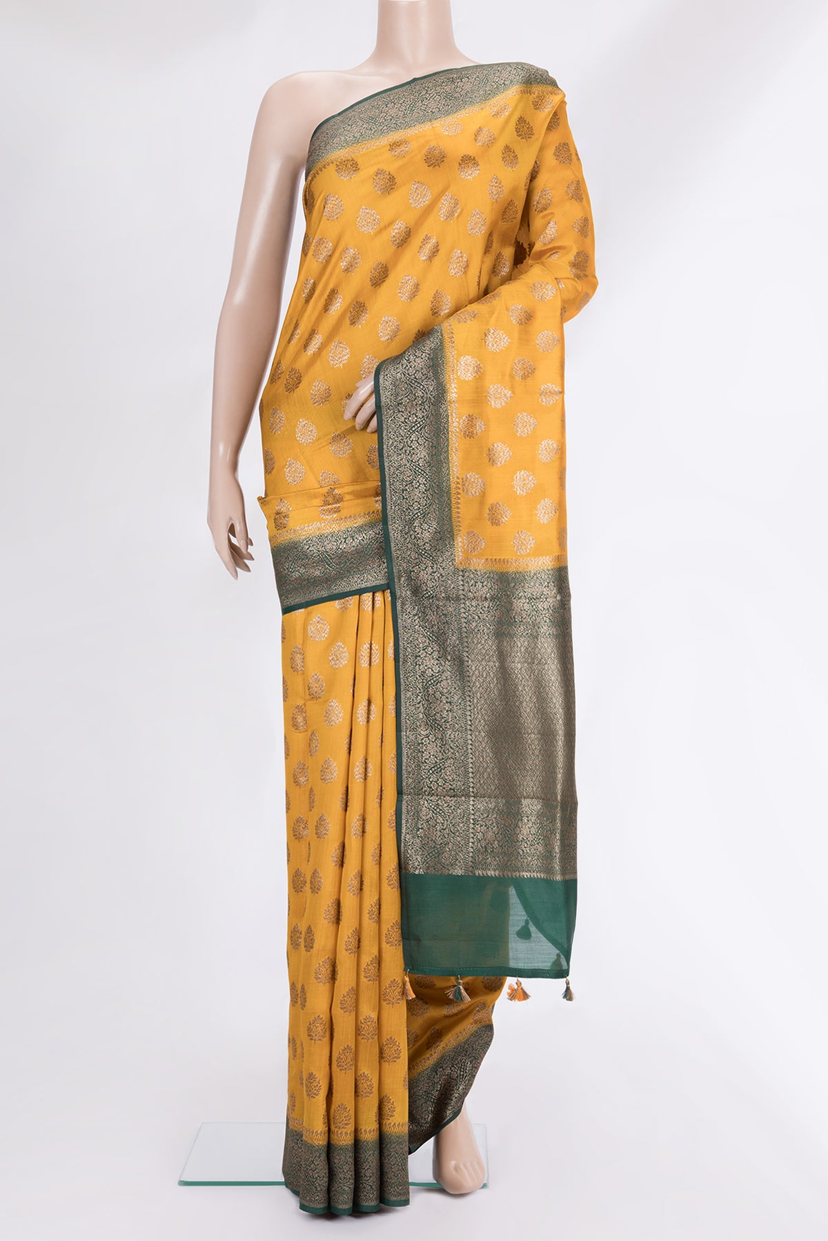 Mustard Raw Saree with Zari Butta on the body and Zari Border.  displayed on a mannequin