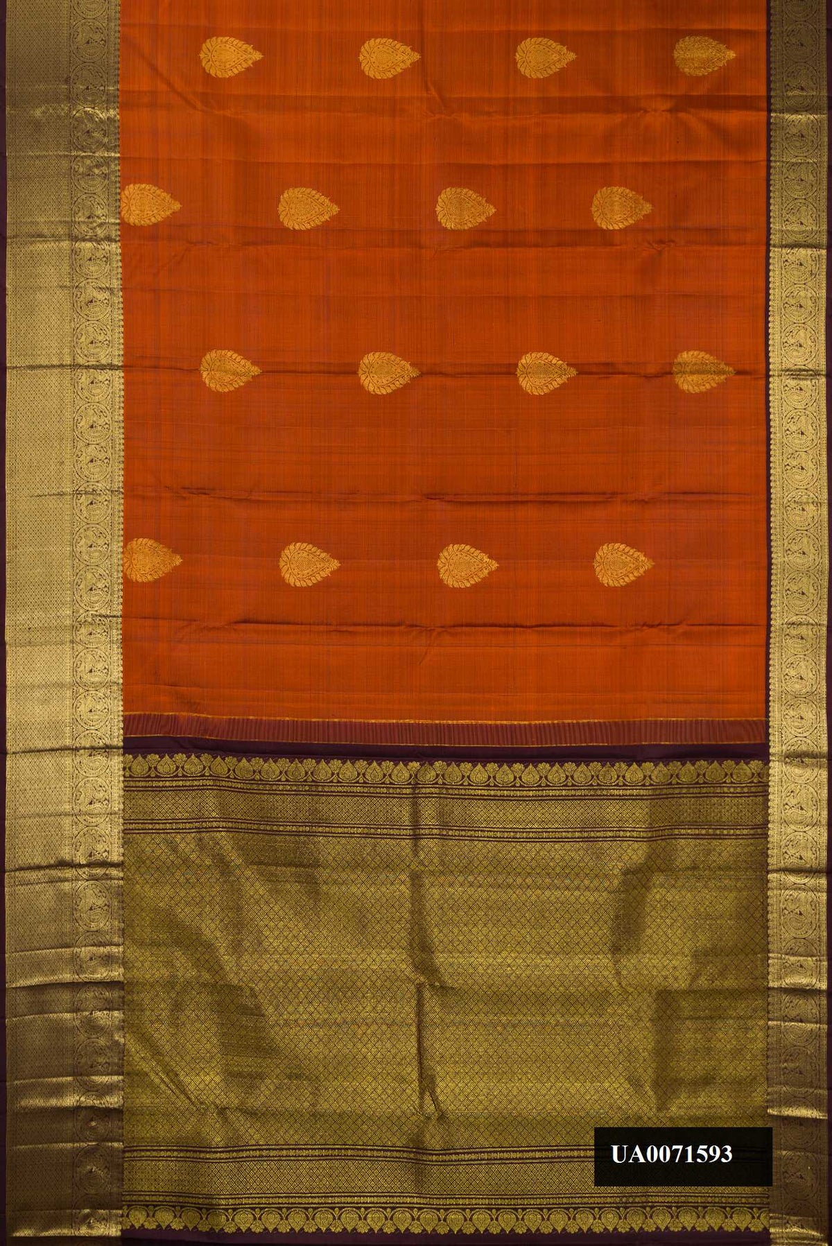 Rust Dual Tone Kanchipuram Silk Saree with Zari Butta on the body and Zari Border.  displayed on a mannequin