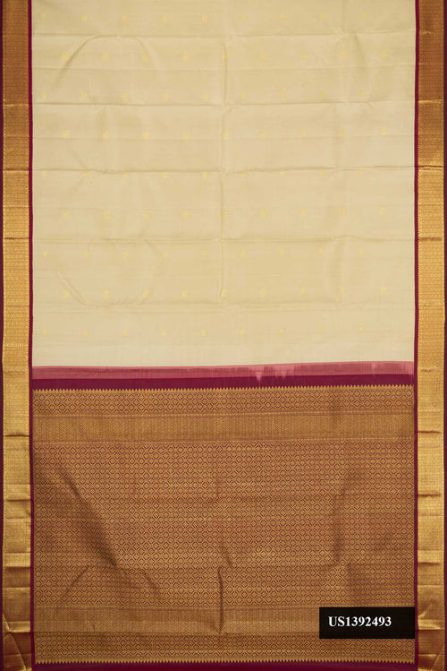 Beige Dual Tone Kanchipuram Silk Saree with Zari Butta on the body and Zari Border.  displayed on a mannequin