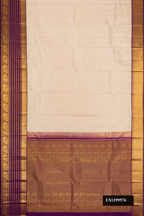 Beige Dual Tone Kanchipuram Silk Saree with Zari Butta on the body and Zari Border.  displayed on a mannequin