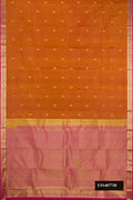 Rust Dual Tone Kanchipuram Silk Saree with Zari Butta on the body and Zari Border.  displayed on a mannequin